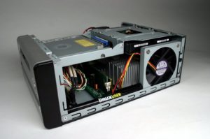 Abbildung 1: Hinter dem LinuxUser-Kugelschreiber erkennen Sie das RAM-Modul sowie den Kühlkörper des Celeron-Prozessors. Darüber befindet sich das Slim-DVD-Laufwerk und die 3,5-Zoll-Festplatte.