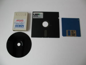 Abbildung 8: So sahen die Speichermedien im vorigen Jahrhundert aus: Links oben ein Modul, in der Mitte eine 5,25-Zoll-Diskette, rechts eine der ersten 3,5-Zoll-Disketten (mit 720 KByte Kapazität). Links unten eine CD-ROM für die Playstation, die Hersteller Sony grundsätzlich nur mit schwarzer Lackierung aus dem Presswerk rollen ließ.