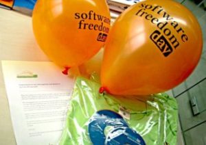 Supply-Kit mit grünem T-Shit, blauen CDs und orangefarbenen Luftballons.