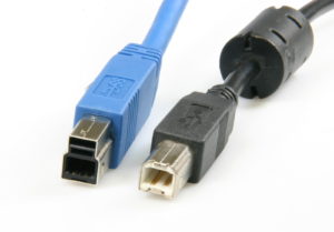 Abbildung 4: USB-B-Endgeräte-Stecker neu (links, blau) und alt (rechts, schwarz). In der obenliegenden Nase des neuen Steckers befinden sich die zusätzlichen Leitungen.