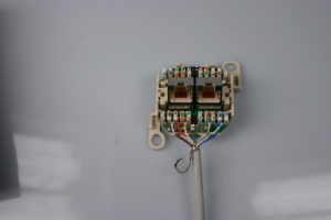 Abbildung 4: Mit einem LSA-Einlegewerkzeug schließen Sie Ethernet-Dosen binnen Minuten an. Die Adernfarben sind auf der Klemmleiste aufgedruckt: Die obere Reihe gibt den inzwischen ungebräuchlichen Standard TIA 568A vor, die untere Reihe gilt für die aktuellen TIA-568B-Norm.