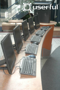 ... wie Arbeitsplätze entstehen sollen. Der große Rechner im Hintergrund beherbergt das Betriebssystem und die Software.
